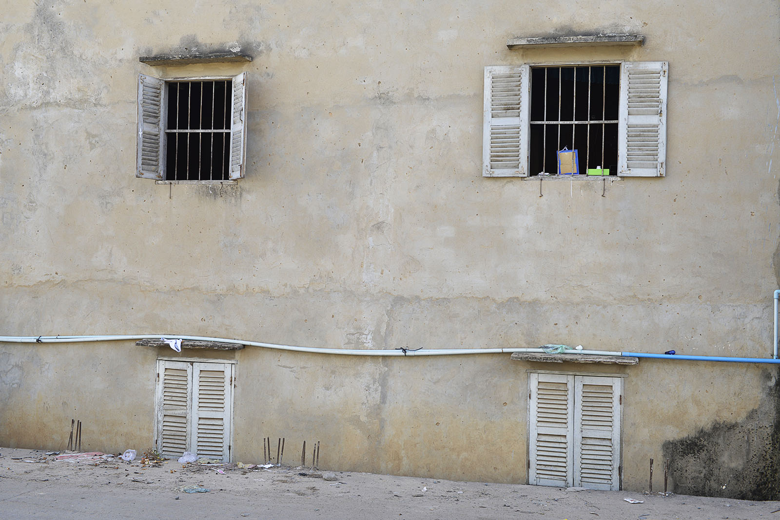 This home in Phnom Penh, Cambodia have a new built concrete road passing buy just inches from the wall and the bottom windows cant be opened any more.